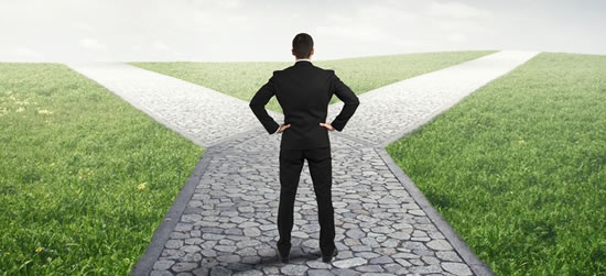 Man standing at a crossroads, arms akimbo.